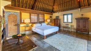 Un dormitorio amplio con una cama grande, muebles de madera y un techo tradicional.