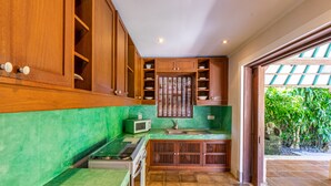 Una cocina con armarios de madera, un microondas y un fregadero.