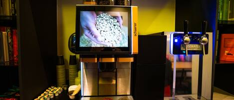 A coffee machine with a screen displaying coffee beans, a coffee dispenser, and a coffee grinder.