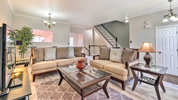 A spacious living room with a sofa set, a glass coffee table, and a lamp. - Pond-View Deck + Pool Table: Woodbridge Haven! (Woodbridge)