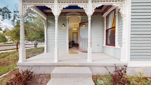 A porch with white columns and a covered entrance. - Retha Victorian - Gunnison (Gunnison)