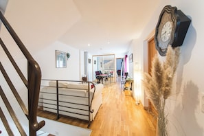 A staircase leading to a bedroom with a bed, a desk, and a chair.