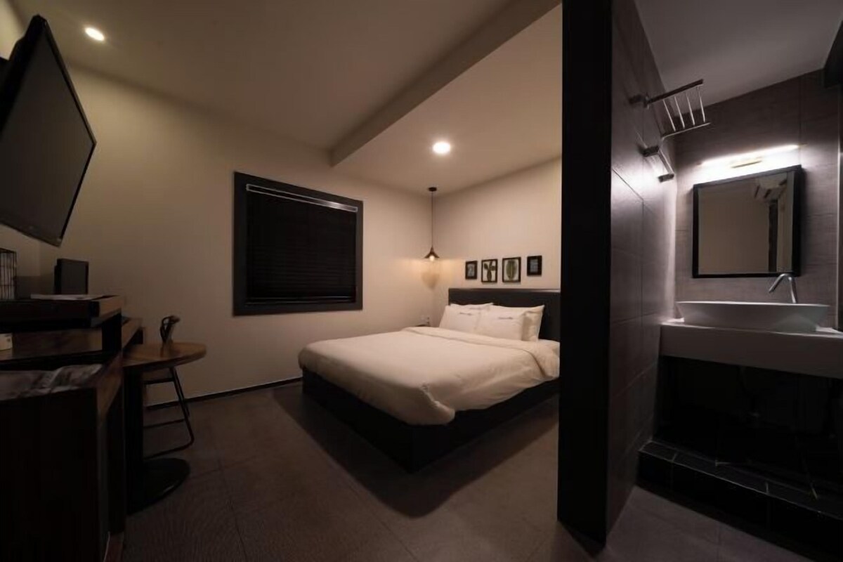 Una camera da letto moderna con un letto, un comodino e un grande specchio.