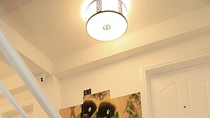 A staircase with white railings leading to a landing with a door and a wall-mounted light fixture. - Abat Guest House (Addis Ababa)