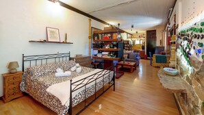 A bedroom with a bed, bedside table, and a wall decorated with bottles.