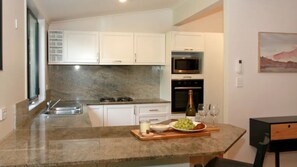 Enjoy cooking in this well-equipped kitchen with a stainless steel sink, microwave, and oven.