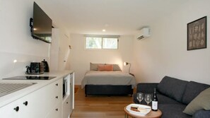 Enjoy a cozy stay in this compact room, featuring a kitchenette, a comfortable bed, and a sofa.