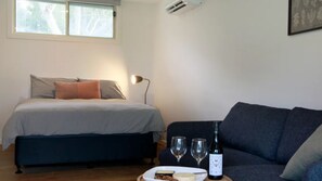 Relax in this serene bedroom with a comfortable bed, sofa, and dining area.