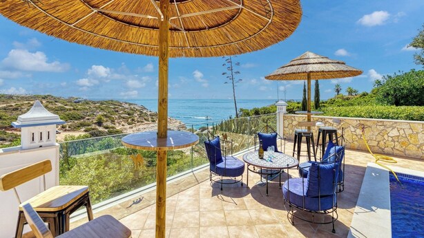 Una terrazza con piscina, area relax esterna e vista sull'oceano.
