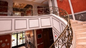 A grand interior with a large, ornate staircase, a high ceiling with a skylight, and a luxurious red and white color scheme. - THE WHITE PALACE RABAT (Rabat)