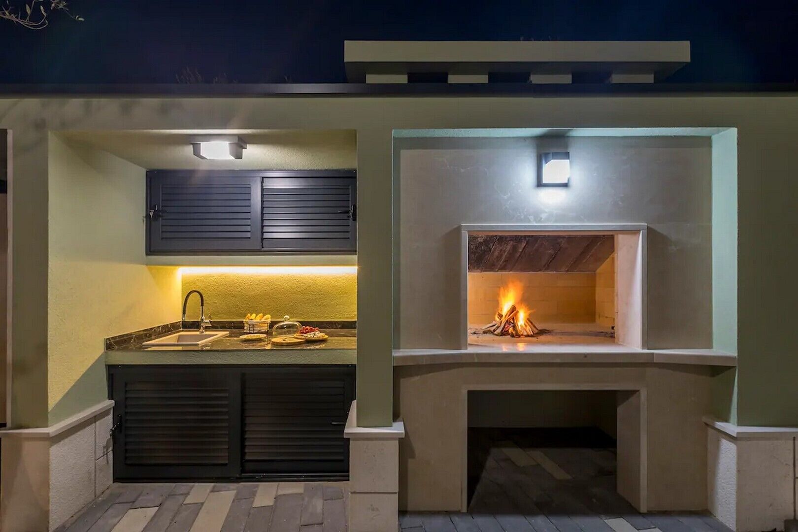 An outdoor kitchen with a built-in grill and a sink.