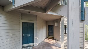 Une maison avec une porte d’entrée bleue, un porche et une boîte aux lettres.