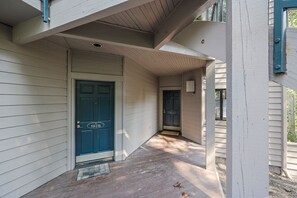 Une maison avec une porte d’entrée bleue, un porche et une boîte aux lettres.