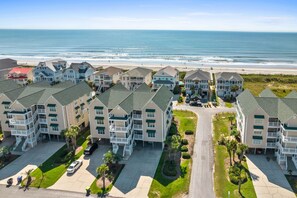 A coastal residential area with multi-story buildings, a beach, and a clear view of the ocean. - CottageVacations4u "The Great Escape"-ocean view villa-pool club-direct beach access (Ocean Isle Beach)