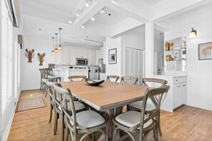A spacious kitchen with white cabinetry, a central island, and pendant lighting. - CottageVacations4u "The Great Escape"-ocean view villa-pool club-direct beach access (Ocean Isle Beach)