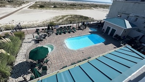 Ein Poolbereich auf dem Dach mit zwei Pools, Liegestühlen und Blick auf den Strand.