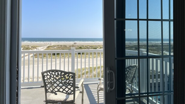 Ein Balkon mit Blick auf den Strand und den Ozean.