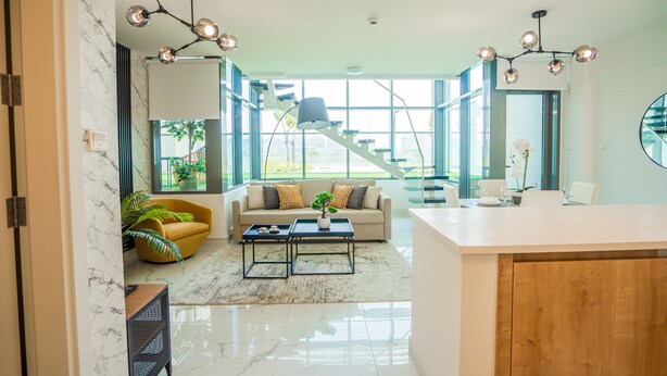 A modern living room with a sofa, coffee table, and a staircase leading to an upper level. - Nasma Luxury Stays - Al Raha Lofts 2 (Abu Dhabi)
