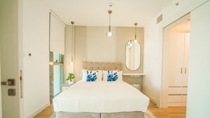 A modern bedroom with a large bed, a bedside table, a mirror, and a wardrobe. - Nasma Luxury Stays - Al Raha Lofts 2 (Abu Dhabi)