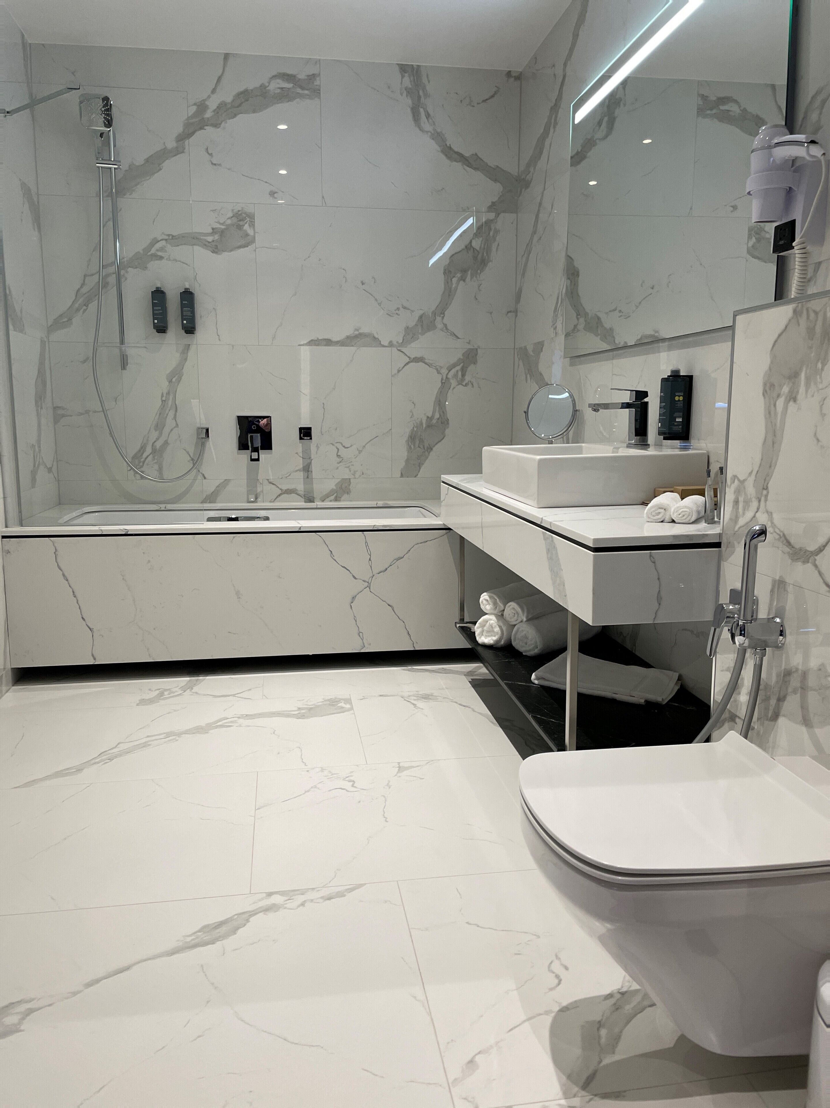 A modern bathroom with a bathtub, a sink, and a toilet.
