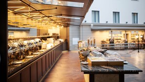 A buffet setup with multiple serving stations and a long counter, likely in a hotel or similar establishment. - VICTORIA Hotel Klaipėda (Klaipeda)