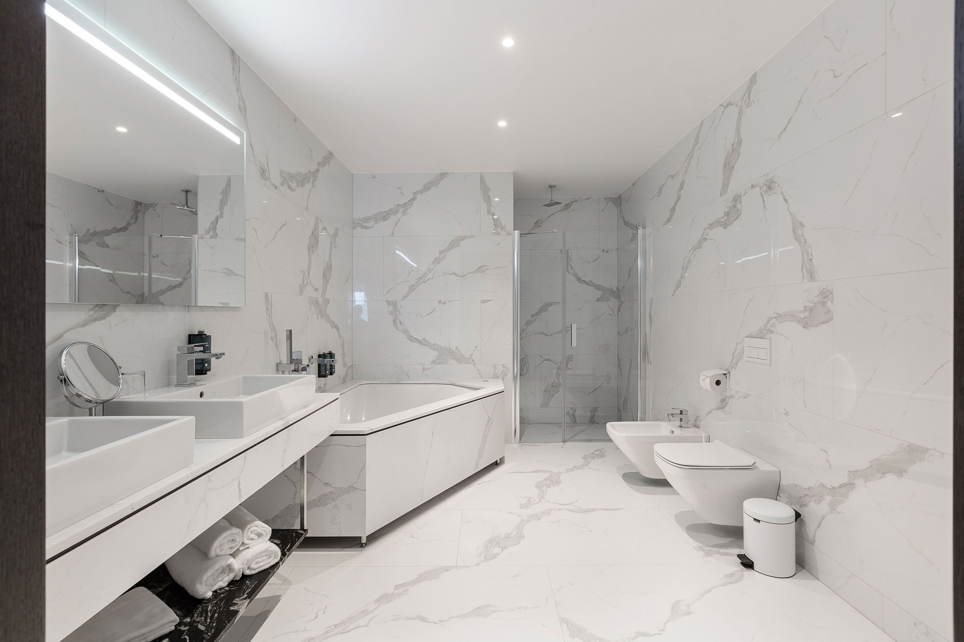 Une salle de bain moderne dotée d’une grande baignoire, d’une douche séparée et d’un bidet.