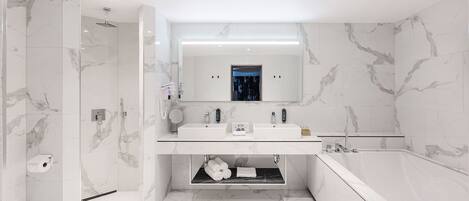 Une salle de bain moderne avec deux lavabos, une grande baignoire et une douche à l’italienne.
