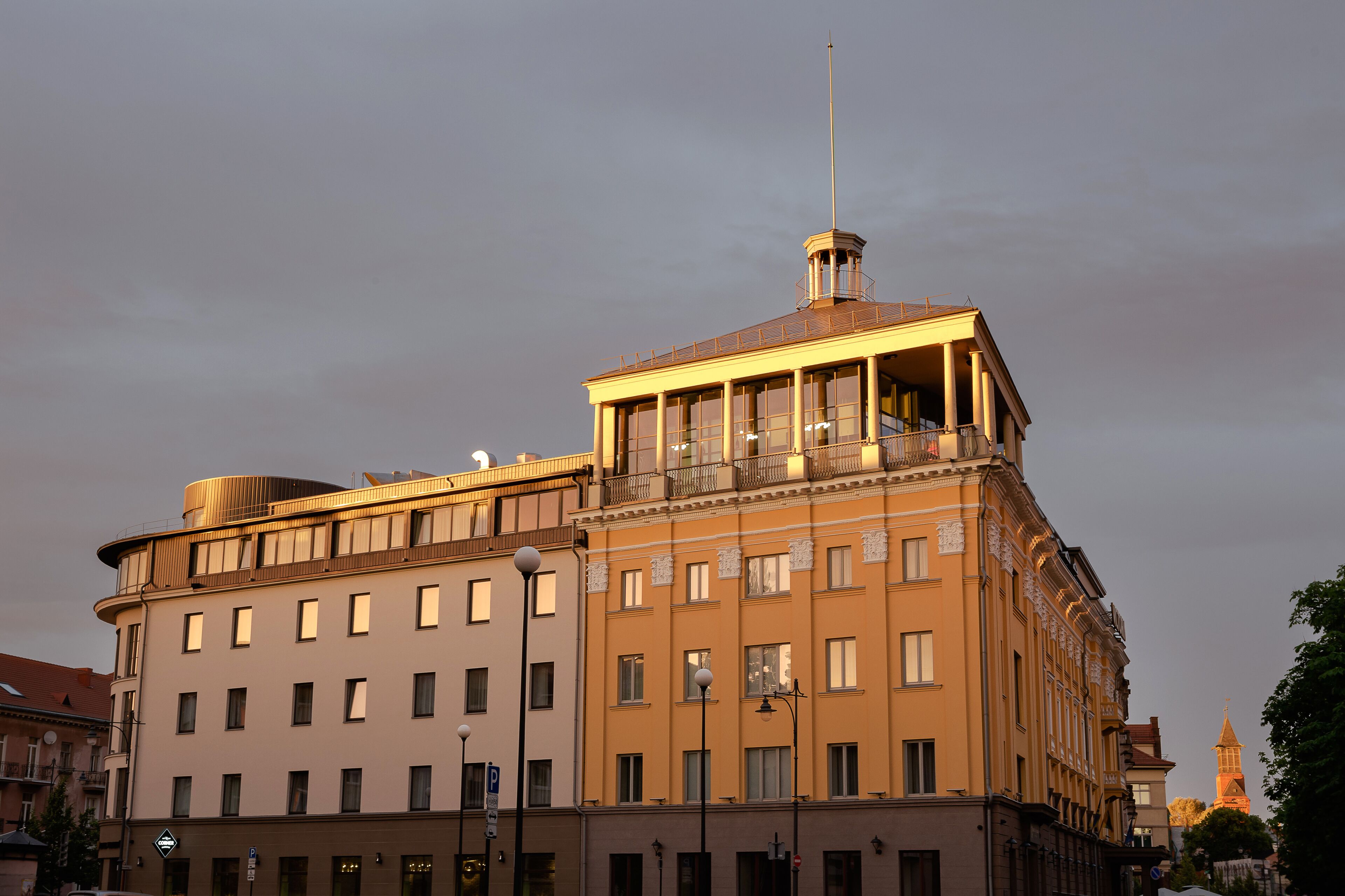 A multi-story building with a prominent tower and a balcony.