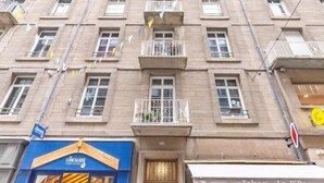A multi-story building with balconies, a blue storefront with 'CNCALISE' signage, and a 'Tabac La Pi' sign. - Le studio St Vincent by Interhome (Saint Malo)