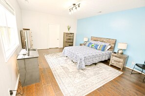 Enjoy a comfortable stay in this room featuring a large bed, nightstand, desk, and large window.