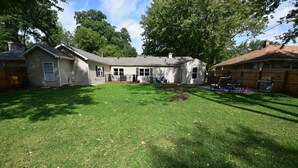 Il s’agit d’une propriété résidentielle dotée d’une pelouse bien entretenue, d’un patio aménagé avec du mobilier d’extérieur et d’un grand jardin.