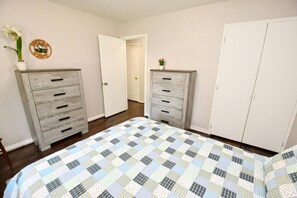 A bedroom with a bed, two dressers, a door, and a small potted plant. - 10 min walk to ND Stadium! (1820) (South Bend)