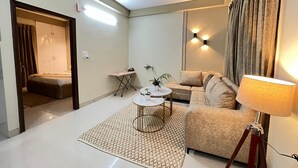 Una sala de estar moderna con un sofá, una mesa de centro, una lámpara y un ventilador de techo.