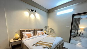 Un dormitorio moderno con una cama grande, lámparas de noche y una lámpara en el techo.