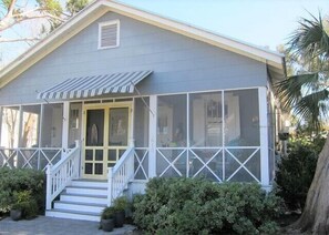 A single-story house with a covered porch, a front door, and a small window. - Ms. Opal's Cottage - POOL! Pet-Friendly! Ground Level (Tybee Island)