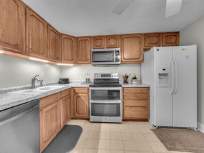 Enjoy cooking in this well-equipped kitchen with a granite countertop, microwave, oven, and dishwasher.