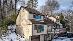 A two-story house with a deck and a garage. - 4 story condo - 100 yard walk to slopes on Sugar Mountain (Sugar Mountain)