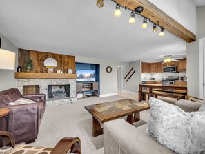 Relax in this cozy living area with a fireplace, sofa, loveseat, and TV.