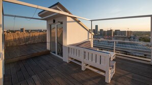 Un rivestimento in legno con una panchina bianca e una porta vetrata che dà su un ambiente interno.
