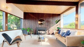 A modern living room with a fireplace, a sofa, and two chairs. - Pano Water View, Fab Deck, Rec Room, King Bed (Port Angeles)