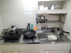 Efficient kitchen with stainless steel stove, sink, and dish rack.