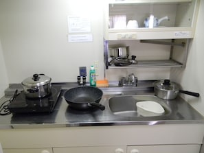 Efficient kitchen with stainless steel stove, sink, and dish rack.