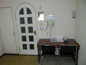 Simple room with a desk, chairs, and telephone.