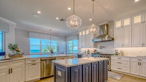 A spacious kitchen with white cabinetry, a central island, stainless steel appliances, and pendant lighting. - I'm Already There - 6 Bedroom Direct Gulf and Intracoastal with Heated Pool (Indian Shores)
