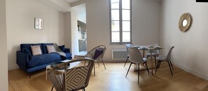 Relax in this stylish living space with a sofa, dining area, and large window.