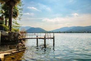 A dock extending into a calm lake with mountains in the background. - Bellariva Lake View (Collina d'Oro)
