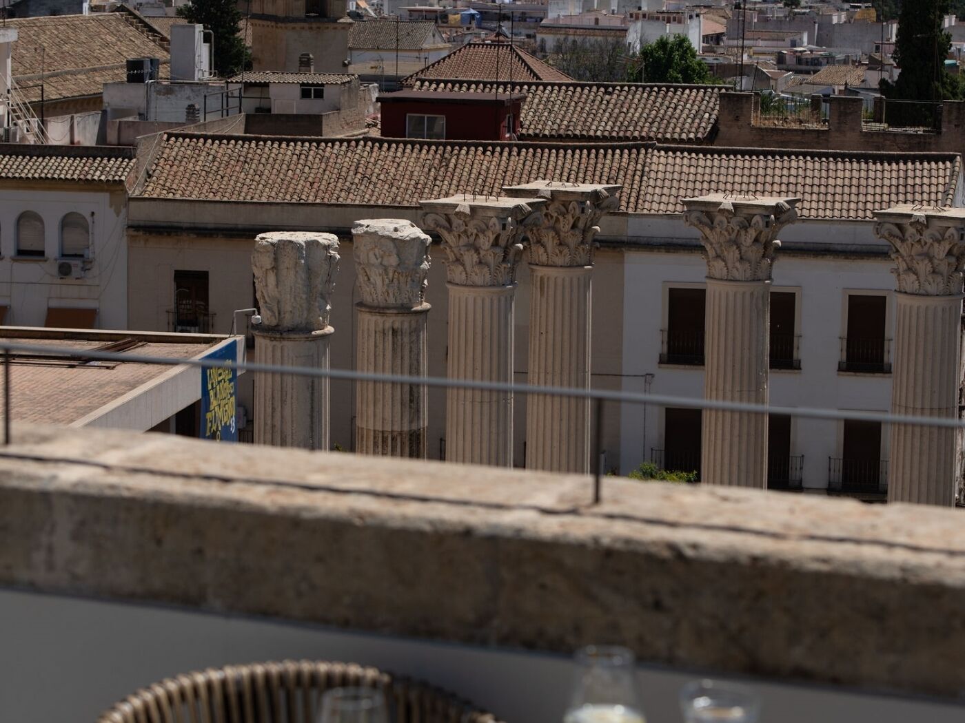 Vista de un edificio con columnas clásicas y techo de tejas, probablemente parte de un sitio histórico o cultural.
