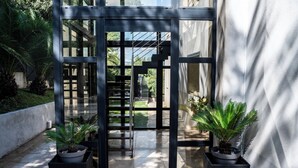 A modern entrance with glass doors, a metal staircase, and potted plants. - Luxury villa in Cannes with pool and jacuzzi (Cannes)