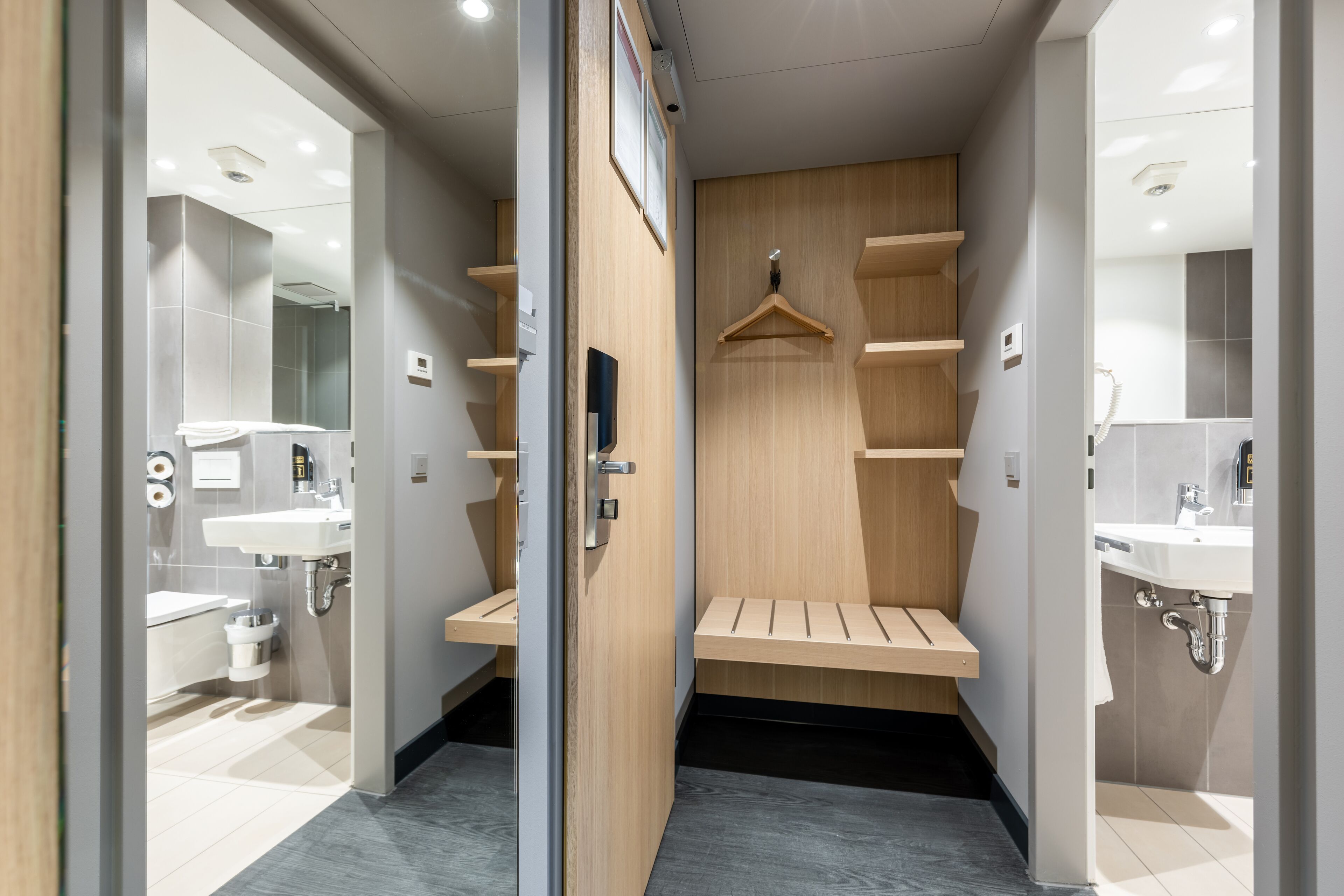 A modern bathroom with two sinks, a mirror, and a wooden bench.