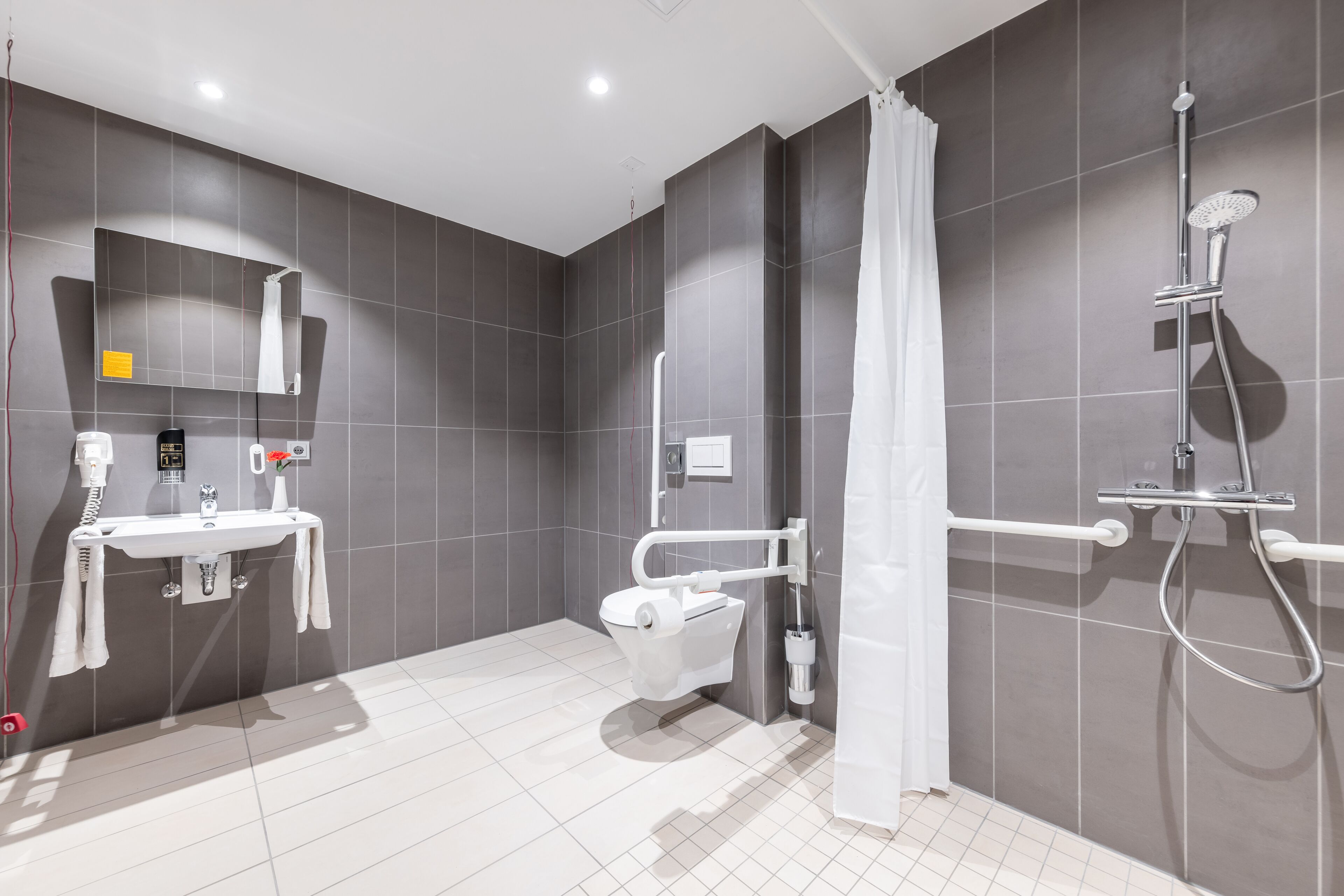 A modern bathroom with a toilet, sink, and shower.